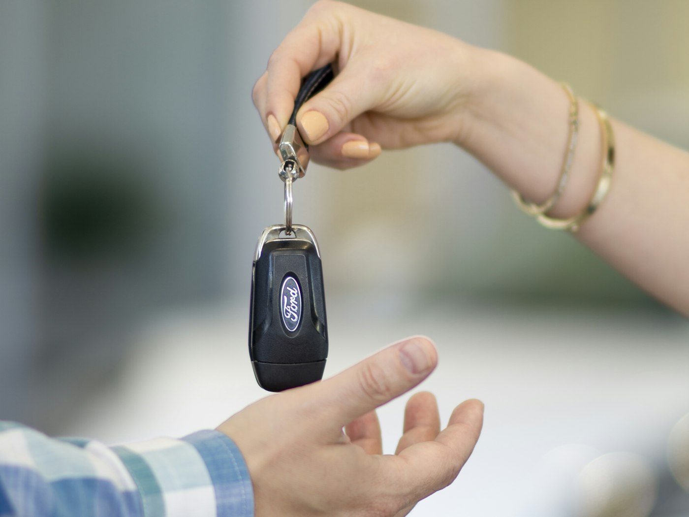 One person handing car keys to another